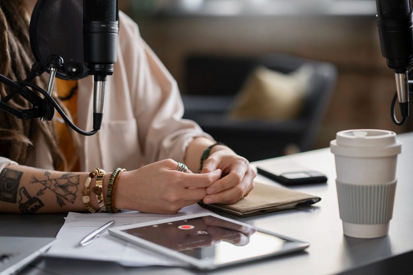 Mulher sentada na mesa gravando um podcast para trabalhar o marketing digital para pequenas empresas