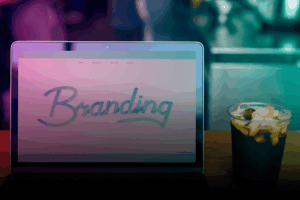 tela do notebook escrito "branding" e um copo de chá gelado com frutas ao lado