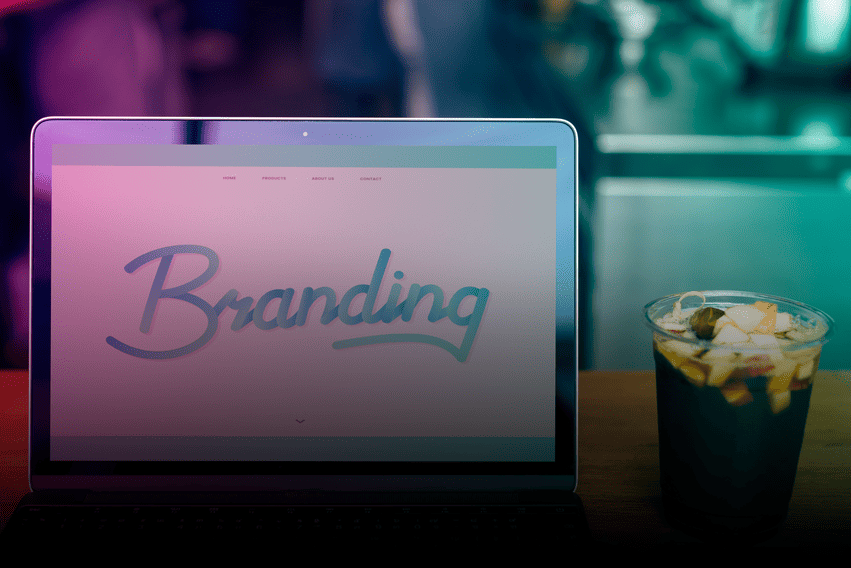 tela do notebook escrito "branding" e um copo de chá gelado com frutas ao lado