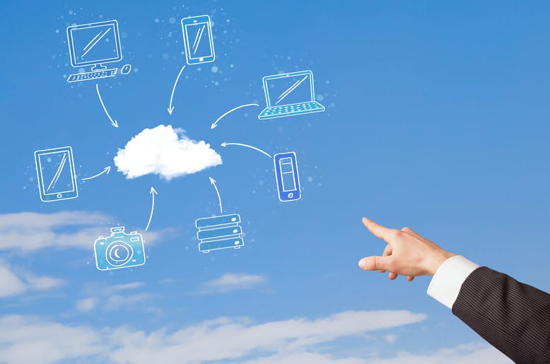 Mão apontando para ícone de nuvem conectado a computador, celular, tablet e outros dispositivos, representando o modelo SaaS