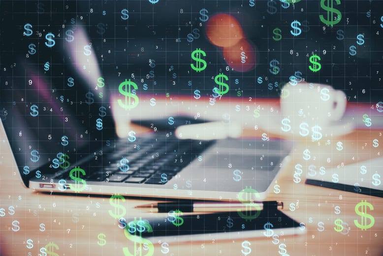 Cifrões flutuando sobre um notebook, representando os modelos de precificação em SaaS